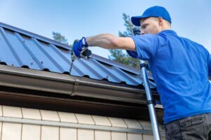Roof eaves with vented soffits, painted fascia, attached gutters, and visible winter weathering. KEYWORDS: ["soffit and fascia roof edge", "vented soffit attic airflow", "damaged fascia and gutter"]